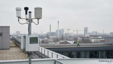 Air quality monitoring station in a European city with hazy skyline
